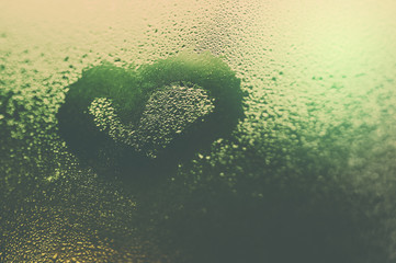 Heart drawn on the glass with lighting and bokeh background,vintage tone