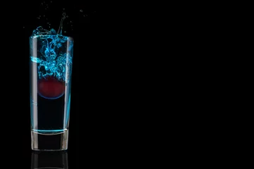 Printed roller blinds Bar Blue cocktail with cherry, splash in glass isolated on black background. Shot alcohol drink.