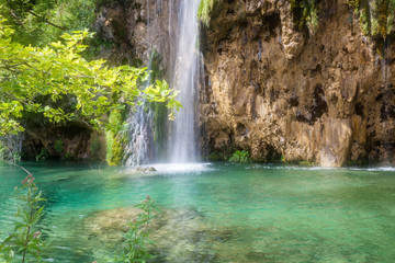 Fototapeta na wymiar Beautiful waterfall in summer green forest