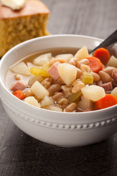 Ham And Bean Soup In A White Bowl With Corn Bread