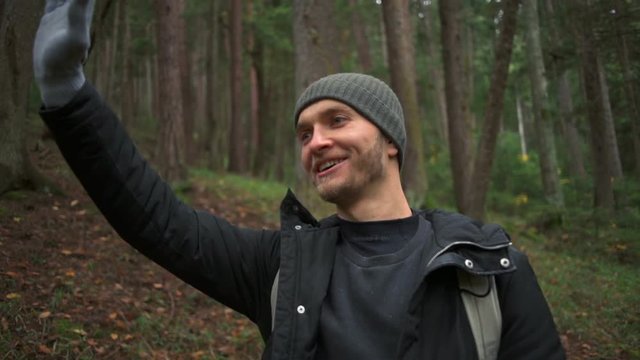 Young handsome man admiring the beautiful forest and waving his hand slow motion