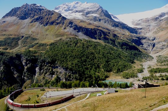 Die Bernina Bahn auf der Fahrt durch die Schweizer Alpen bei der Alp Grüm zum Bernina Hospiz. The Bernina train on its way from Alp Grüm to Bernina Hospitz driving through the swiss alps.