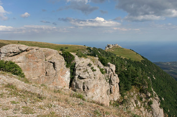 Fototapeta na wymiar The mountain landscape with sunlit limestone cliffs. This photo was taken in Crimean Mountains, on South Demerdzhi mountain.