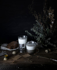 still life. vintage. a simple country breakfast on  wooden table. milk, bread, eggs. black background