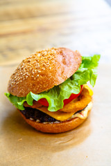 Hamburger with cheese, steak, onion rings and salad.