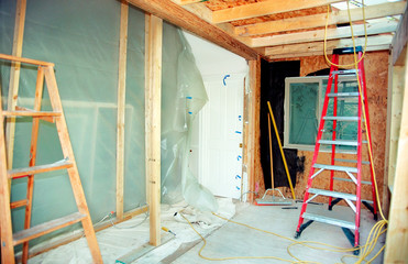 Plastic tarp covers the missing wall as bedroom is extended with a reading area. Roof supports in...