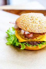 Hamburger with cheese, steak, onion rings, lettuce, pineapple an