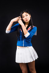 Asian woman clasped her fingers all together and expressing positive or negative emotions to camera in studio. Pretty lady posing for photographer.