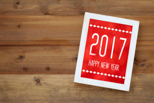 Happy new year 2017 on white vintage wooden frame on wood