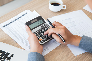 Man using calculator to count income and outcome