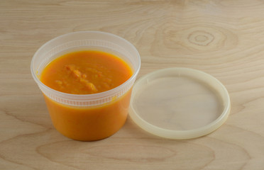 Fototapeta na wymiar Butternut squash yam and carrot soup in plastic container for healthy take to work meal