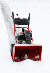 Naklejka premium snow blower removing snow on the driveway
