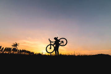 Fototapeta na wymiar Silhouette man with mountain bicycle at sunset