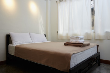 Fototapeta na wymiar white king size bed, two pillows and towel in bedroom for rest and relax.