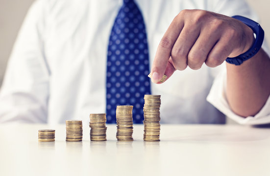 Business man's hand put money coins to stack of coins. Money, Financial, Business Growth concept, 