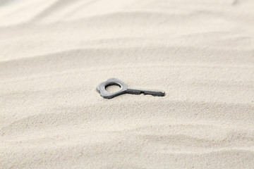 Fototapeta na wymiar Vintage key on sand