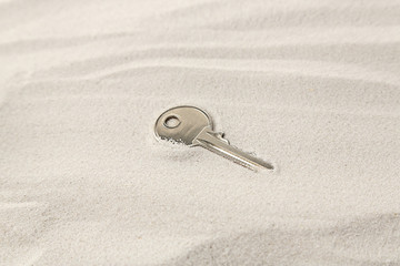 Fototapeta na wymiar Vintage key on sand