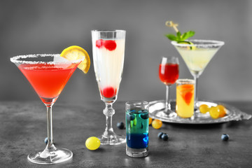 Different cocktails with sweet berries on gray table
