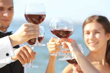 People clinking glasses at party outdoors, close up view