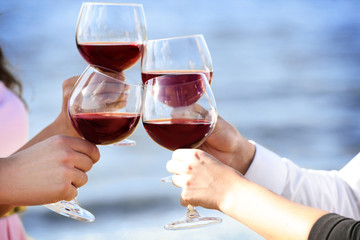 People clinking glasses at party outdoors, close up view