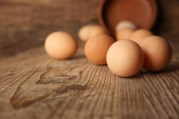 Raw eggs on wooden board, closeup