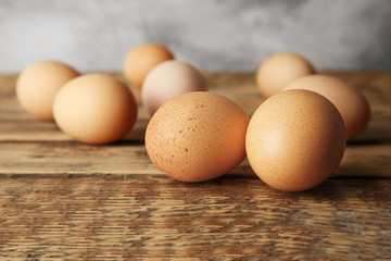 Raw eggs on wooden table