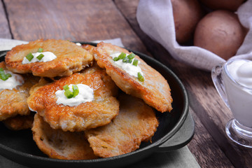 Pan with tasty potato pancakes for Hanukkah on wooden table, closeup