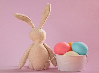 Easter bunny with eggs on color background