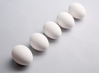 Row of white eggs on light background