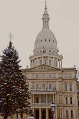 A photo of the State of Michigan Capitol Building with a Christmas tree in the foreground