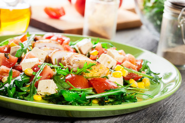 Fresh salad with chicken breast, arugula and tomato