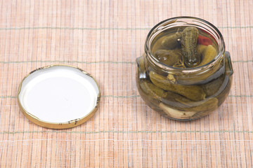 Natural organic dill cucumbers in jar on bamboo placemat