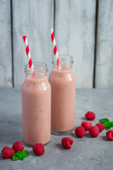 Raspberry homemade milkshake in bottles and scattering of berrie