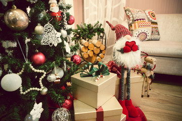Christmas tree in a family house with gifts and ornaments close up