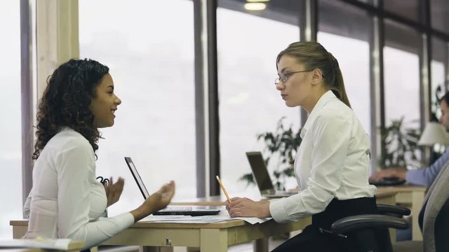 Serious lady HR manager interviewing young student, taking trainee for probation