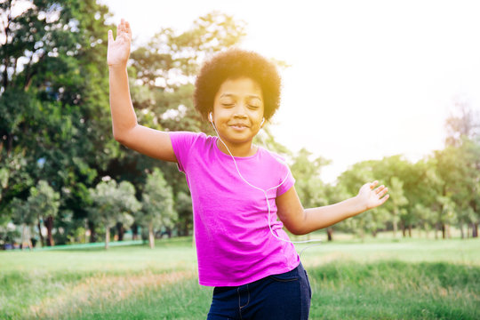 Little Kid Dancing And Listening To Music In Green Park