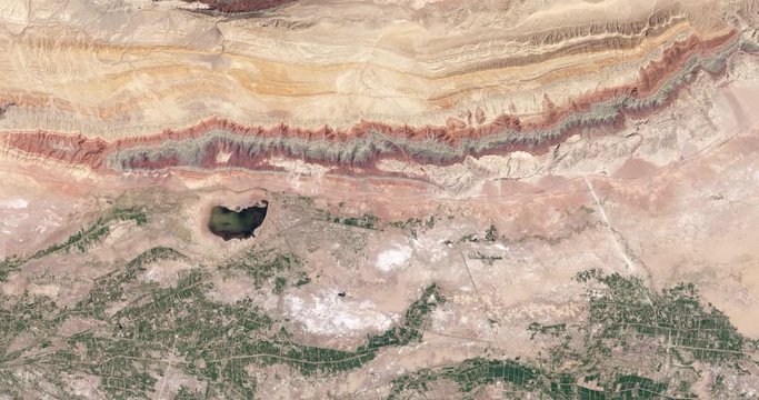 High-altitude overflight aerial of thrust belt rock layers, Xinjiang province, China. Clip loops and is reversible. Elements of this image furnished by USGS/NASA Landsat