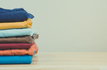Stack of colorful clothes on wood table, Housework and objects concept, Vintage filter
