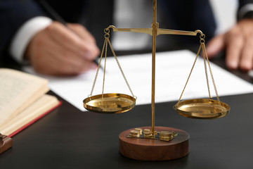 Scales of justice on table, closeup