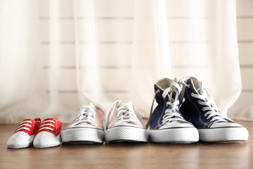 Family concept. Shoes for parents and child on floor in the room