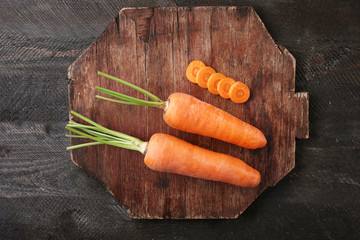 Fresh carrots on wooden cutting board