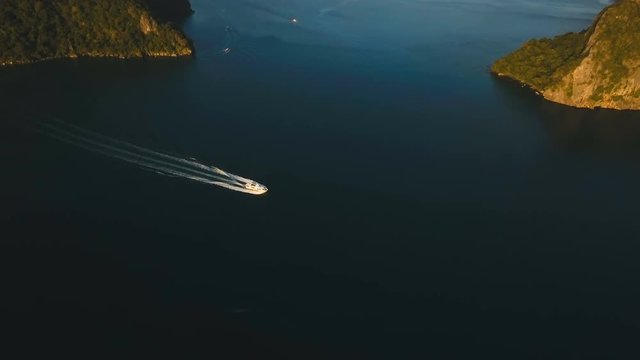 Aerial view of speed boat in sea. Motorboat crossing ocean. Speed boat sailing between the islands. Tropical landscape. Philippines, El Nido. 4K video. Travel concept.