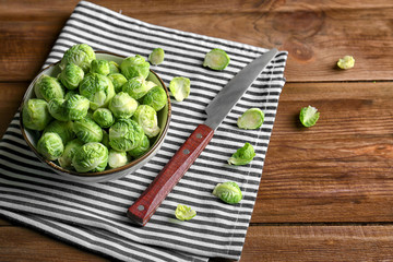 Brussels sprouts in bowl with knife on wooden table