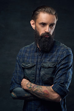 Bearded hipster male with crossed arms.