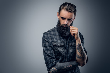 Bearded male with tattoos on his arms.