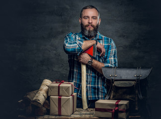 Fototapeta premium Middle age male holds an axe and gift boxes.