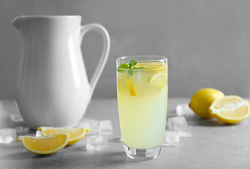 Glass of refreshing lemonade on table