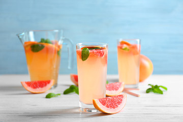 Glass of refreshing grapefruit drink on table