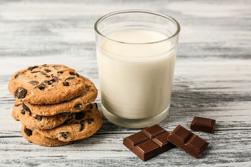 Chocolate cookies with milk on wooden background