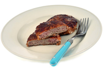 Grillettes de porc dans une assiette sur fond blanc